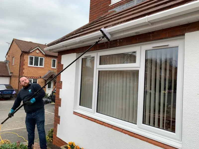 Soap Soul team member cleaning windows on a residential property in the Forest of Dean
